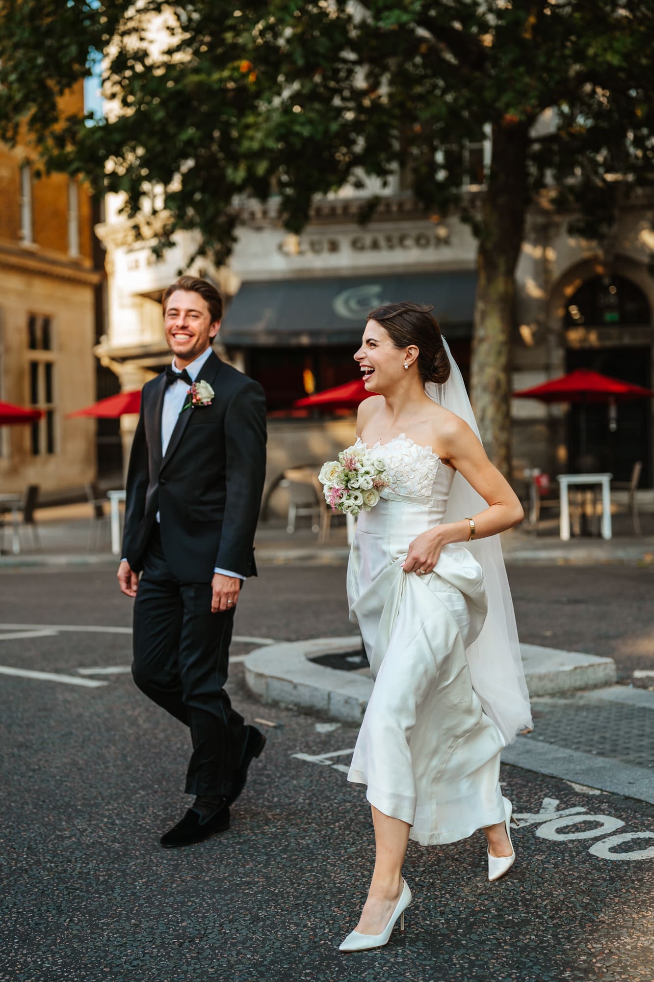 Couple laughing as they cross a busy street, one of my favourites from my Best of 2024 Documentary wedding Photography