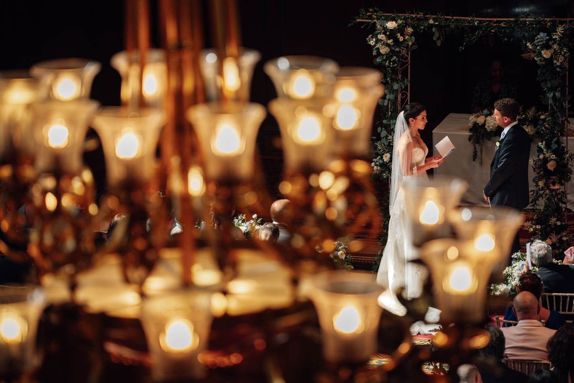 Bride and groom raise a toast in the Great Hall, captured in Merchant Taylors' Hall wedding photography, by Ben Lee