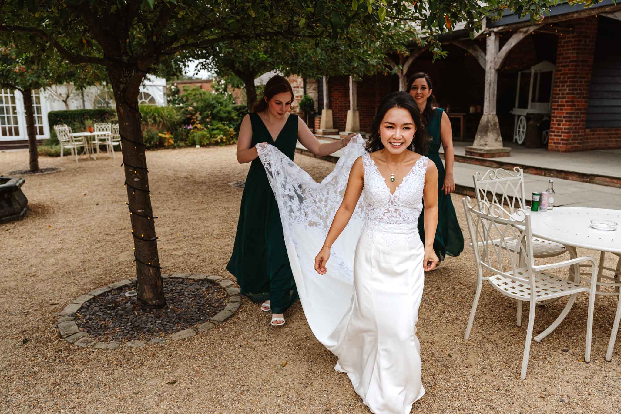 Bride and bridesmaids walking to an outdoor wedding ceremony,  captured in Micklefield Hall wedding photography, by Ben Lee