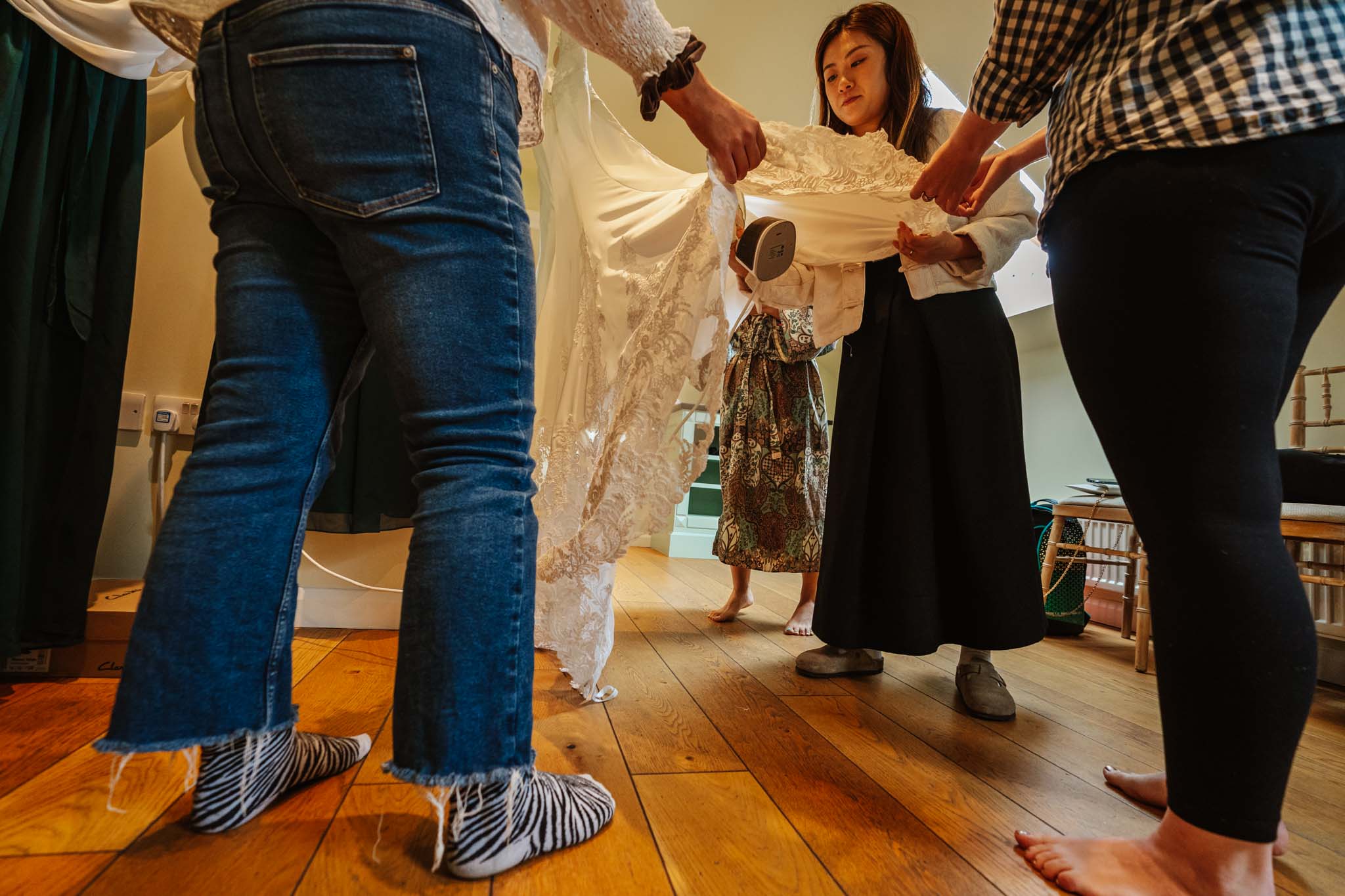 steaming a wedding dress,  captured in Micklefield Hall wedding photography, by Ben Lee