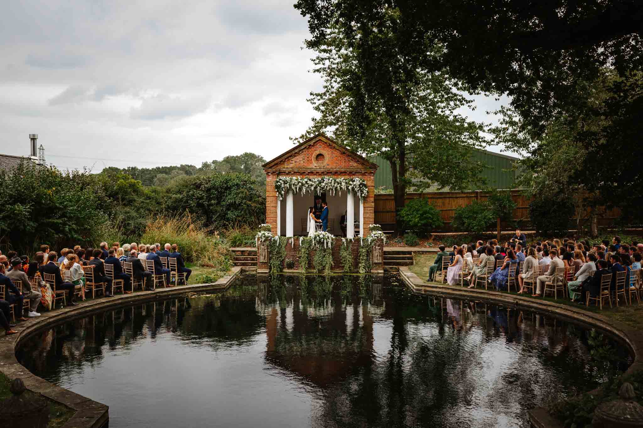 Bride and groom saying their vows in the garden temple, captured in Micklefield Hall wedding photography, by Ben Lee