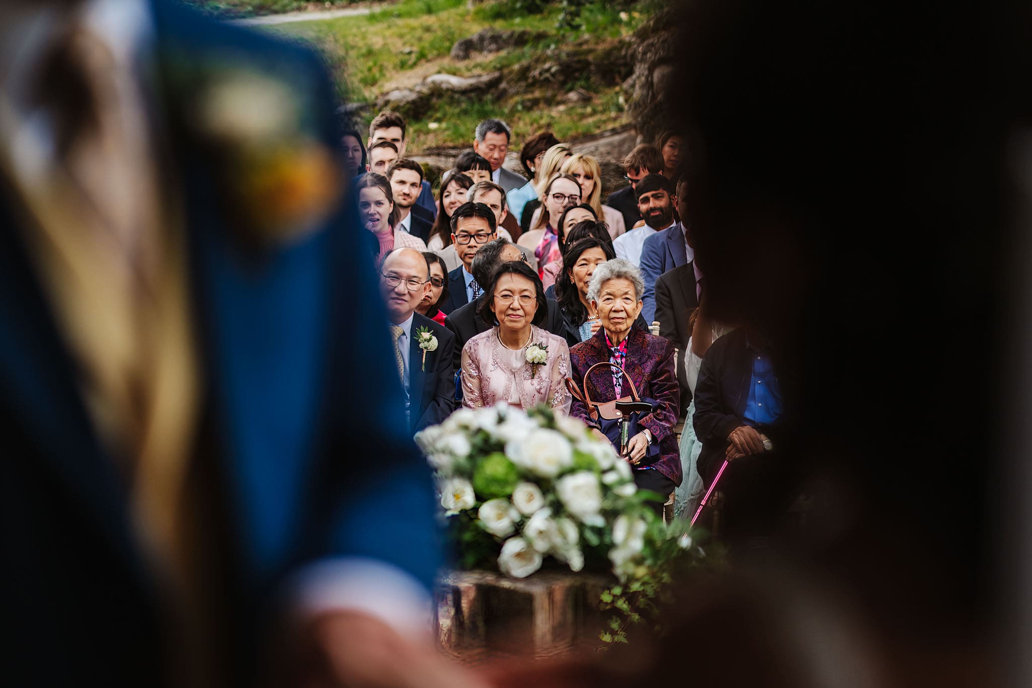 Guests witnessing a marriage at an outdoor wedding ceremony, captured in Micklefield Hall wedding photography, by Ben Lee