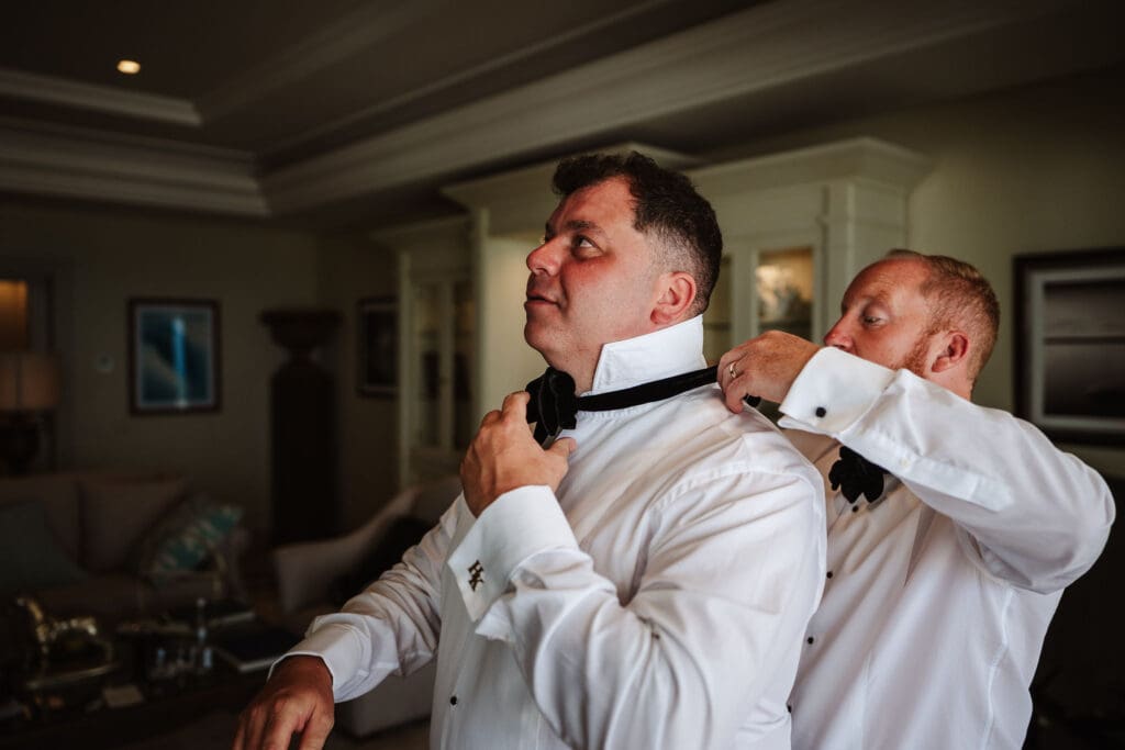 Tying the groom's tie captured in wedding photography in Tangier, Morocco by Ben Lee.
