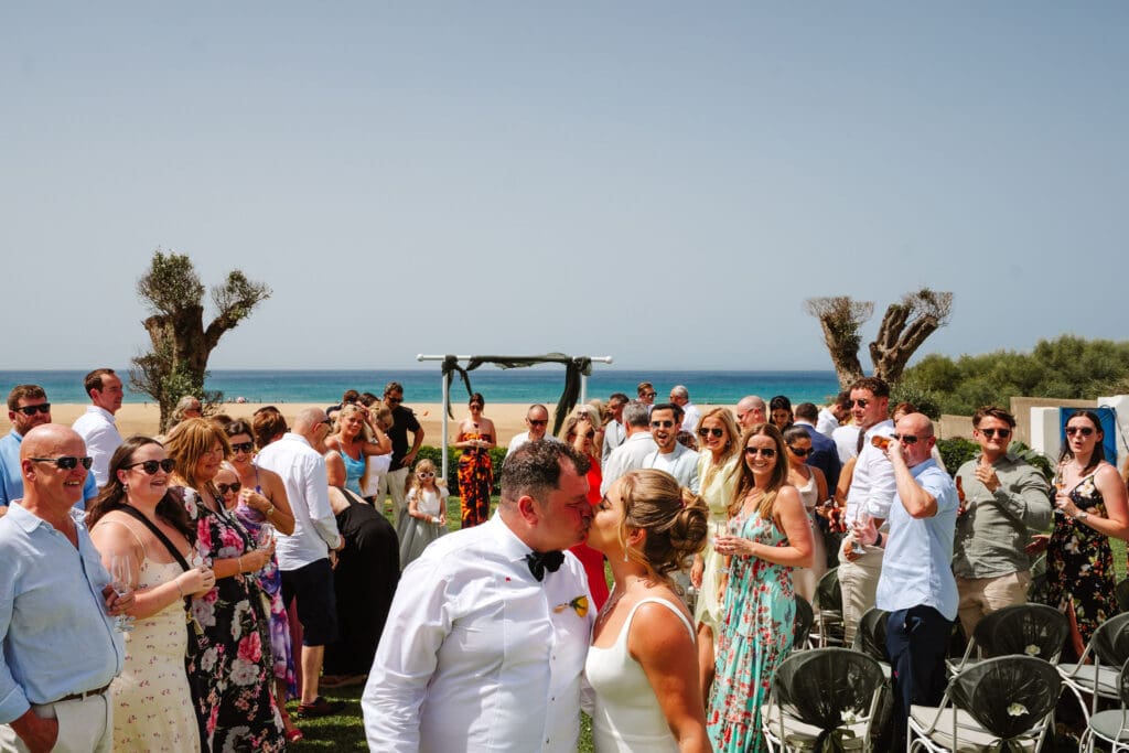 bride and groom kiss at beachfront ceremony captured in wedding photography in Tangier, Morocco by Ben Lee.