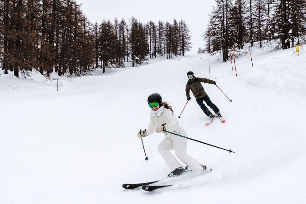 bride and groom ski downhill together, captured in ski wedding photography in Italy, by Ben Lee
