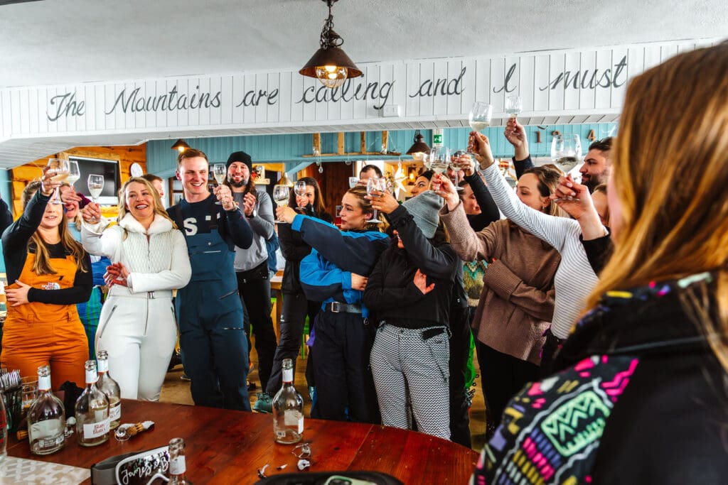 toasting the newlyweds captured in ski wedding photography in Italy, by Ben Lee