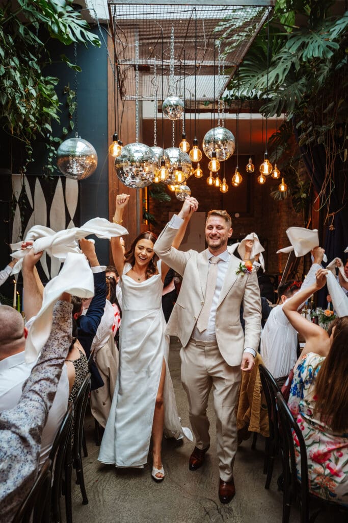 Bride and groom make an entrance to their wedding at the Hackney, captured by Ben Lee Photography